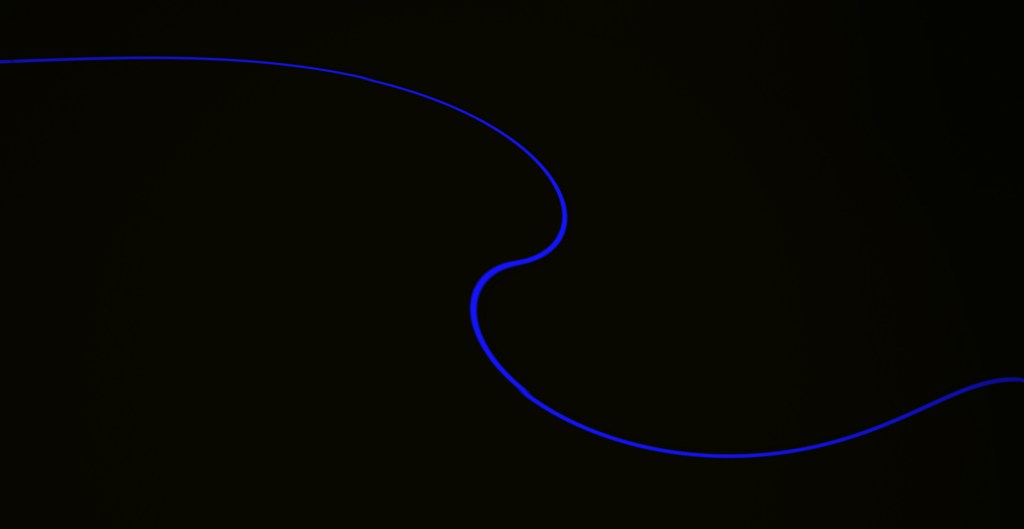 Photo is of a wavy thin blue line and a black background.